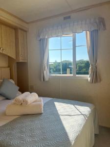 蘭彼得的住宿－Heavenly Retreat，一间卧室配有一张带毛巾的床和窗户。