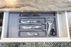 a drawer filled with silver utensils in a cabinet at AStar Apartments - EXTRA LARGE in Rădăuţi
