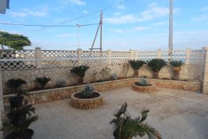 eine Terrasse mit Topfpflanzen vor einem Zaun in der Unterkunft California in Bari