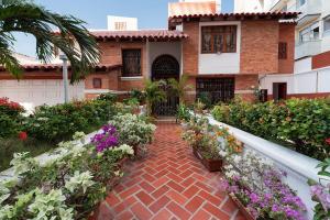 a house with flowers in front of it at Villa Santos Apartaestudios in Barranquilla