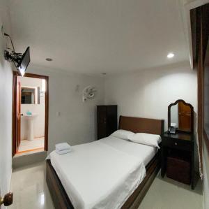 a bedroom with a bed and a mirror and a sink at Hotel Sangil Tuluá in Tuluá