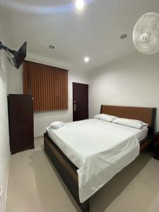 una camera con un grande letto e un ventilatore di Hotel Sangil Tuluá a Tuluá