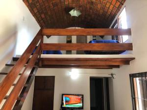 a loft bed in a living room with a ladder at Refugio Atlántico in San Bernardo