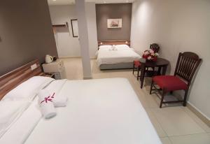 a hotel room with a bed and a table and chairs at One Avenue Hotel Balakong in Seri Kembangan