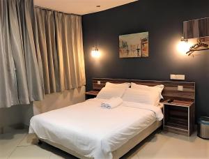 a bedroom with a large bed with white sheets at One Avenue Hotel Balakong in Seri Kembangan
