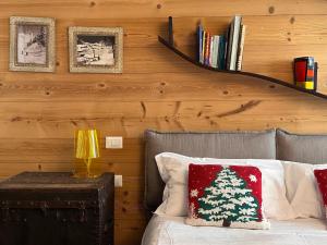 a room with a bed with a christmas pillow and a book shelf at Maison Rododendro Elegant in Breuil-Cervinia