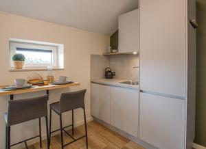 a kitchen with a white refrigerator and a table with chairs at Barn24 - The Sty in Roggel