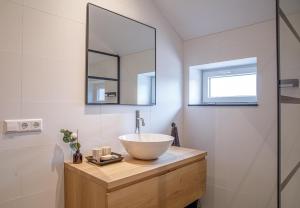 a bathroom with a bowl sink and a mirror at Barn24 - The Sty in Roggel
