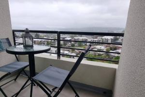 a table and chair on a balcony with a view at Departamento nuevo en Villarrica in Villarrica