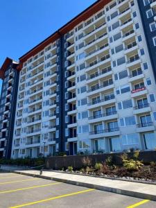 a large apartment building with a parking lot in front of it at Departamento nuevo en Villarrica in Villarrica