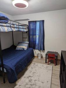 - une chambre avec des lits superposés et une chaise rouge dans l'établissement Little Blue House On Coyle Street, à Springhill