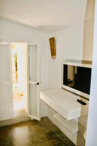 een witte woonkamer met een tv op een witte kast bij Can Joseph I in Sant Francesc Xavier