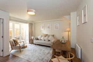 a living room with a couch and a table at Harpers Yard - 30 Chipping Norton in Chipping Norton
