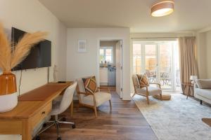 a living room with a desk and chairs at Harpers Yard - 30 Chipping Norton in Chipping Norton