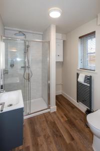 uma casa de banho com um chuveiro e um lavatório. em Harpers Yard - 30 Chipping Norton em Chipping Norton