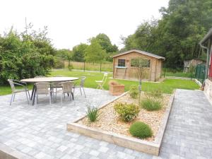 un patio con tavolo e sedie in un cortile di Gîte des Bois Rimbert a Beuzeville