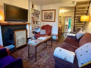 sala de estar con sofá y chimenea en Bumblebee Cottage - Cosy Cottage in Area of Outstanding Natural Beauty, en Hemel Hempstead