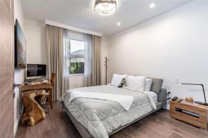 1 dormitorio con 1 cama grande y TV en Luxury House in Pembroke Pines Newly Renovated With Pool And Security, en Pembroke Pines