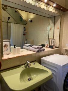 baño con lavabo verde y espejo en ApartVilla Trieste, en Trieste