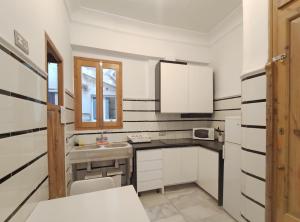 a white kitchen with black and white stripes on the walls at Entre la Estación y el Ayuntamiento in Valencia