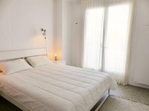 białe łóżko w białej sypialni z oknem w obiekcie HOSSEGOR Plage Centrale Résidence ATLANTIC Appartement pour 4 personnes Wifi gratuit w mieście Soorts-Hossegor