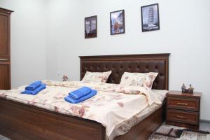 ein Schlafzimmer mit einem Bett mit blauen Kissen darauf in der Unterkunft Chinara Guest House Airport in Taschkent