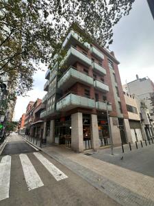 un palazzo alto in una strada di città di fronte a un edificio di Cozy Apartment Les Corts a Barcellona