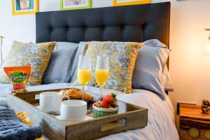 a tray of food and two glasses of orange juice on a bed at Cocoa River - Quiet city centre, close to the Shambles, on the river, two bed, two bath, allocated parking in York