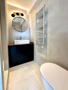 y baño con lavabo blanco y espejo. en Laureto BnB, en Roquebrune-Cap-Martin