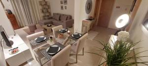 - un salon avec une table et des chaises en verre dans l'établissement Baia Village - Praia do Castelo - Galé - Albufeira, à Albufeira