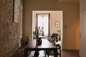 uma sala de jantar com uma mesa de madeira e cadeiras em Rustic Style Apartments & Studios BCN em Barcelona
