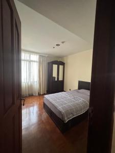 - une chambre avec un lit et une grande fenêtre dans l'établissement Kusuma Chandra SCBD Apartement, à Jakarta