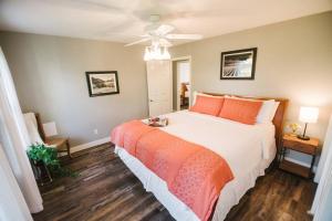 a bedroom with a large white bed with orange pillows at Haymakers Inn - Peaceful Country Views in Paso Robles