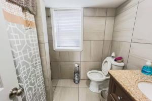 a small bathroom with a toilet and a window at Large 6BR, 6 Bath in the city of Niagara Falls in Niagara Falls