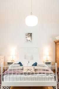 1 cama blanca en un dormitorio con 2 lámparas en VB36 Vendégház en Villány