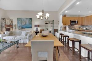 eine Küche und ein Wohnzimmer mit einem Tisch und einem Sofa in der Unterkunft Redfish Village 409 top floor stay on 30A in Seagrove Beach