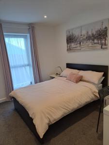 um quarto com uma cama com uma fotografia na parede em Royal Atlantic View Apartment em Portrush