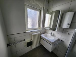 a bathroom with a sink and a mirror and a window at Dhh for fitters and craftsmen in Baden-Baden