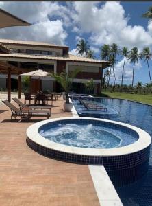 uma grande piscina em frente a uma casa em house13_itacimirim em Camassari