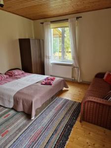 1 dormitorio con cama, ventana y alfombra en Püha Guesthouse en Püha