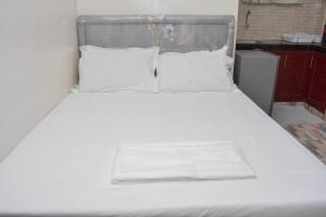 a white bed with white sheets and pillows at NIKO HOMES in Mombasa