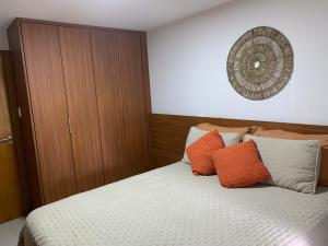 um quarto com uma cama com almofadas laranja e branca em house13_itacimirim em Camassari