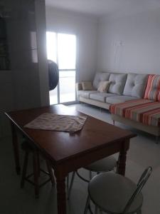 een woonkamer met een tafel en een bank bij Apt° completo vista para o mar! in Praia Grande