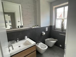 uma casa de banho com um lavatório, um WC e um espelho. em Winkelschiffchen III mit Sauna em Juist