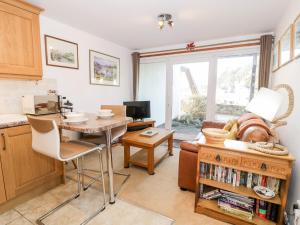 a kitchen with a table and a living room at 48A South Snowdon Wharf in Porthmadog