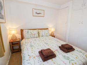 a bedroom with a bed with two towels on it at 48A South Snowdon Wharf in Porthmadog