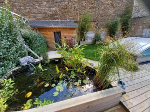 a koi pond in the backyard of a house at Appartement, 2eme étage avec piscine partagée in Sedan