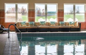 a swimming pool with a couch in a building at Rodd Crowbush Golf & Beach Resort in Morell