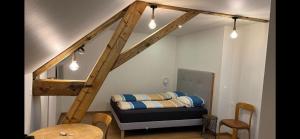 Zimmer mit einem Bett und einer Treppe mit Licht in der Unterkunft Studio cosy au centre de Couvet in Couvet