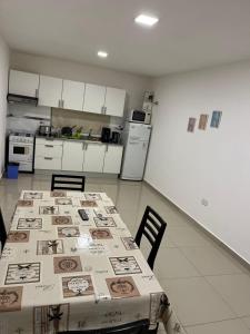una cucina con tavolo e tovaglia; di Departamentos Temporarios ATLAS a Presidencia Roque Sáenz Peña